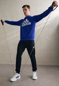 adidas Sportswear SPORTSWEAR HOODED TRACKSUIT SET - Tuta - semi lucid blue/black