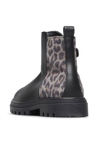 Bottines noires avec des panneaux en daim léopard, semelle épaisse à nervures et une languette à l'arrière.