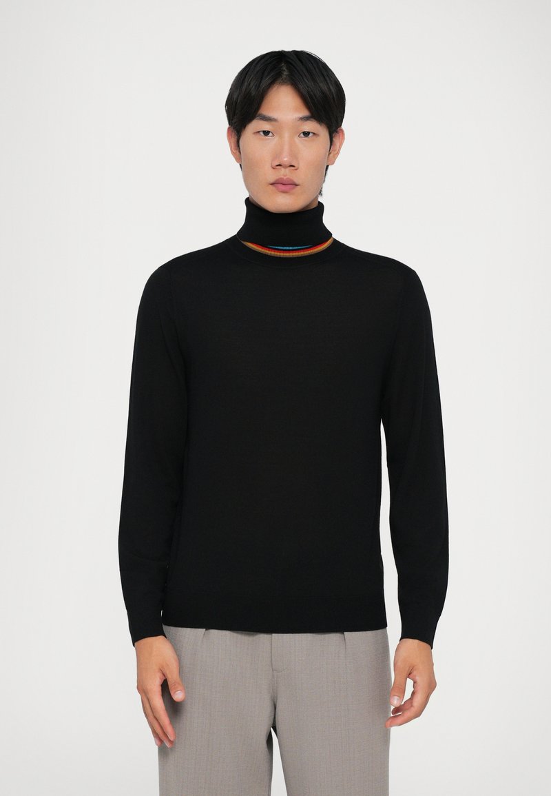 Crni sweater s visokim ovratnikom i prilagođenim dizajnom, napravljen od mekog materijala. Ima višebojni naglasak na izrezu i duge rukave.