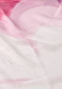 Tela rosa y blanca con un efecto de acuarela, que presenta una sutil textura de purpurina y pequeñas partículas brillantes dispersas por toda la superficie.