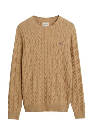 Kabelstrikket genser i beige med rund hals, ribbede mansjetter og nederkant, med en liten brodert logo på brystet.
