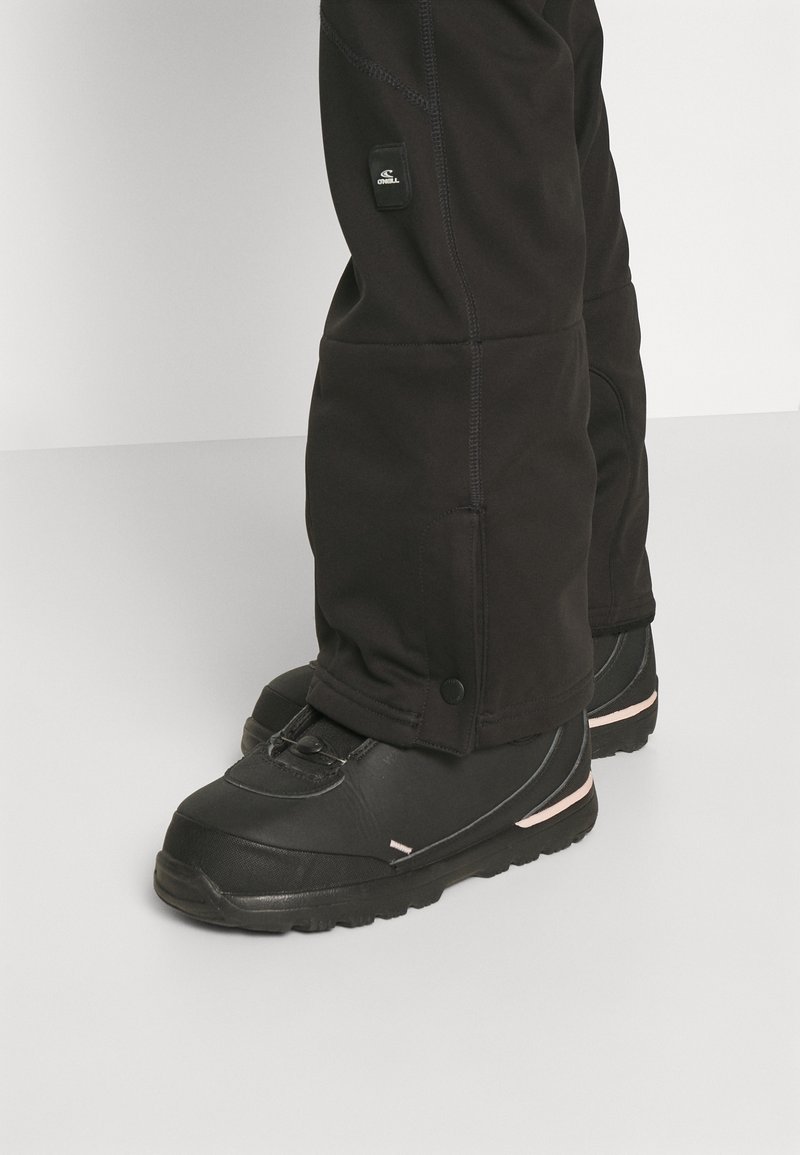 Czarne ocieplane buty śniegowe z fakturowanym wykończeniem, z okrągłym systemem blokady sznurówek i subtelnym różowym akcentem na podeszwie.