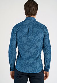Blauwe gestructureerde lange mouwen shirt met paisley ontwerpen, zachte stof, knopenmanchetten en een rugplooien voor extra comfort.