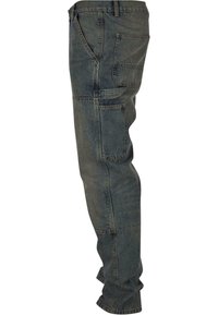 Denim cargo pants in dark blue with a slightly faded texture, featuring multiple side pockets and a relaxed fit.