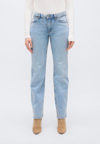 Blugi din denim albastru deschis cu design cu picior drept, cinci buzunare și închidere cu nasture. Tivul este ușor ciufulit, cu un finisaj estompat.