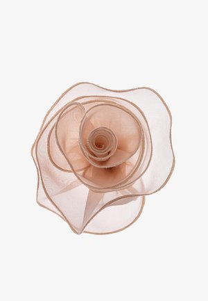 Bežna prozračna tkanina oblikovana u spiralnu ružu s nježno zakrivljenim rubovima na bijeloj pozadini.