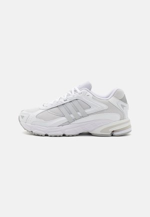 White athletic sneaker with gray accents, mesh panels, lace-up design, and cushioned sole, shown from the outer side on a plain background.