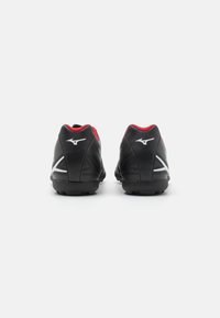 Scarpe sportive nere con un design elegante, accenti rossi e una tomaia sintetica texturizzata. Presentano un profilo basso e una suola in gomma resistente.