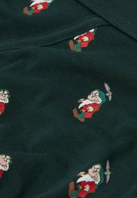 Mörkgrön tyg med små broderade dvärgkaraktärer i röda och gröna kläder, som visar upp olika poser och accessoarer.