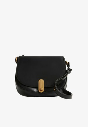 Bolso bandolera de cuero negro con solapa curvada, cierre ovalado dorado y correa de hombro ajustable enrollada sobre fondo blanco.