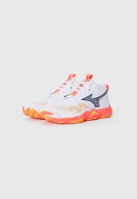 White athletic shoes with orange and yellow patterned soles, black logo on sides, and orange pull tabs and accents.