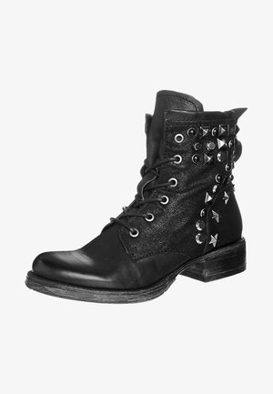 Czarne botki za kostkę z okrągłym noskiem, wykonane ze skóry, zdobione dekoracyjnymi ćwiekami i metalowymi akcentami. Mają sznurowane zapięcie z przodu oraz teksturowane boki.