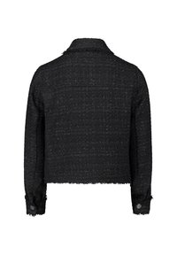 Czarna marynarka z tweedu o postrzępionych brzegach, kołnierzu i zapięciach na guziki. Teksturowany materiał o krótkim, kwadratowym kroju.