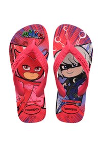 Tongs rouges avec des personnages de bande dessinée sur une semelle texturée, dotées de brides en caoutchouc roses et d'une semelle marquée. Les motifs comprennent des graphiques d'action.