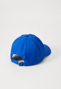 Blå bomull baseball cap med en buet skjerm, justerbar stropp og ventilasjonsøyler. Har en jevn tekstur med ensfarget design.