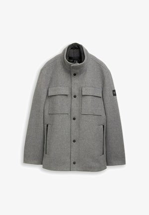 Pilkas vilnos švarkas su aukšta apykakle, priekiu užsegamas snap užtrauktukais, dviem krūtinės kišenėmis ir dviem šoninėmis kišenėmis su užtrauktuku; tekstūruota medžiaga su lygiu pamušalu.