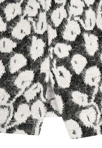 Schwarz-weißes Stoffmuster mit Tierdruck und weichem, strukturiertem Gefühl. Zeigt deutliche, verschwommene Leopardflecken auf einem Netz-Hintergrund.