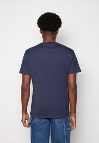 Mörkblå bomullströja med kort ärm och rundad halsringning, med en mjuk textur och rak fåll.