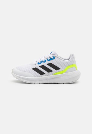 Scarpa sportiva bianca con tomaia in rete traspirante, strisce nere, accenti blu sui lacci e suola gialla fluorescente e bianca.