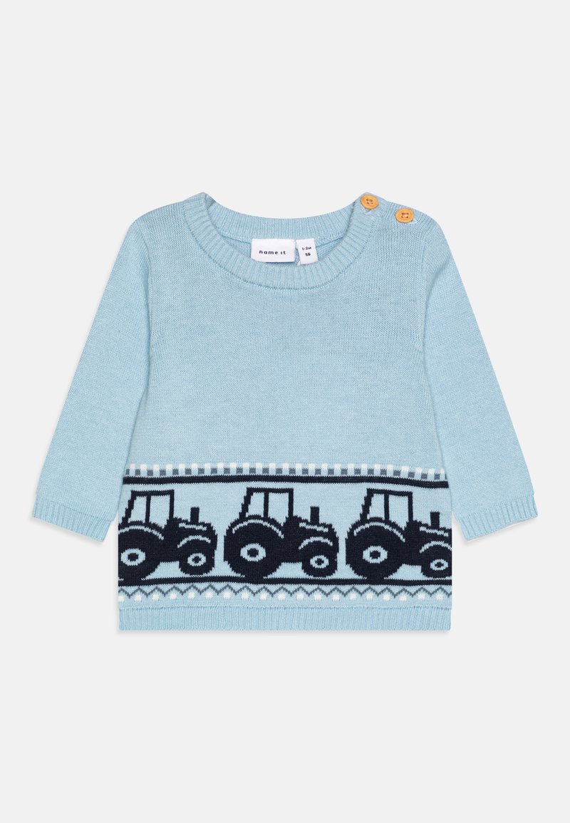 Maglione lavorato a maglia di colore azzurro chiaro con maniche lunghe, caratterizzato da un motivo di trattori in blu navy lungo il fondo e dettagli con bottoni in legno sulla spalla.