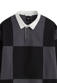 Svart, grå och mörkgrå randig polo skjorta med vit krage. Har en knappslå och strukturerad tyg.