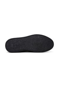 Suela de zapato negra con una superficie texturizada, bordes curvados y un diseño plano. Incluye un pequeño detalle de logo grabado cerca del talón.