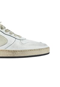 Sneaker low-top in suede bianco con un design testurizzato, dettagli grigio chiaro e una suola in gomma con un bordo nero a contrasto.