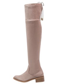 Kozaki za kolano z miękkiego beżowego zamszu, z zaokrąglonym noskiem, niskim obcasem typu słupek oraz wiązaniem na górze dla regulowanego dopasowania.