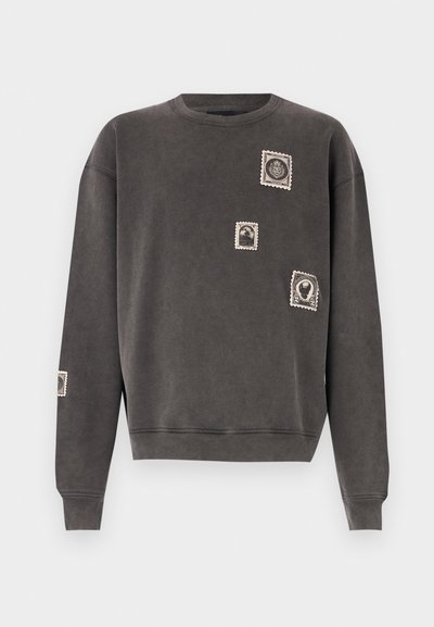 Sudadera gris de mezcla de algodón, con cuello redondo, mangas largas y apliques decorativos de sellos postales bordados.