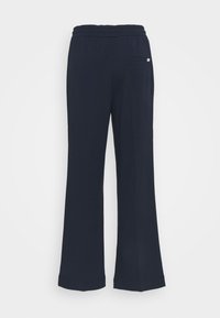 Navy blue flared sweatpants with an elastic waistband, featuring a back pocket and smooth texture. Simple design without patterns or accents.