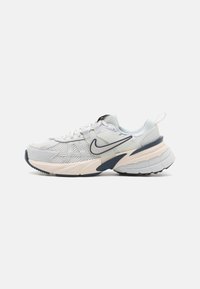 Sportskor med en ljusgrå mesh-övre, marinblå detaljer, en tjock vit mellansula och en strukturerad svart gummiskal.