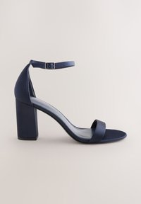 Tmavomodrá dámska sandála na vysokom podpätku s remienkom okolo členku, blokovou podrážkou a jedným predným remienkom, zobrazená z boku na neutrálom pozadí.