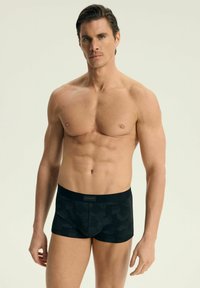 Czarne bokserki z teksturowanym geometrycznym wzorem, z miękkim paskiem w talii i małą metką marki z przodu.