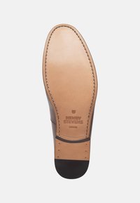 Semelle en cuir marron avec des détails de couture, une surface lisse et la marque "HENRY STEVENS BERLIN". Un talon en caoutchouc noir accentue le design.
