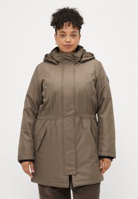 Parka almofadada castanha com capuz, apresentando uma cintura ajustada, dois bolsos frontais e detalhes com botões de pressão. Textura suave, design de comprimento médio.