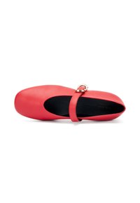 Bailarinas de cuero rojo con punta redondeada, tira en el tobillo con hebilla dorada y textura mate suave. Plantilla negra visible.