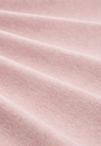 Svetlo roza tkanina z gladko teksturo in subtilnim tkanjem, ki prikazuje nežne gube in sence.