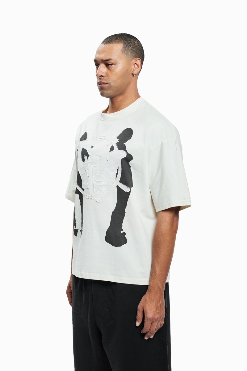 Weißes BaumwollT-Shirt mit schwarzem Grafikdruck, das ein Design einer Figur zeigt. Lockere Passform, runder Ausschnitt und kurze Ärmel.
