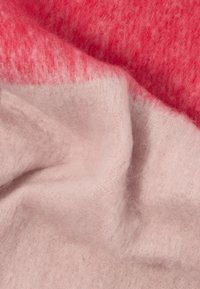 Tecido suave e pelúcido com um degradê que vai do rosa claro ao coral brilhante, mostrando dobras suaves e detalhes de textura.