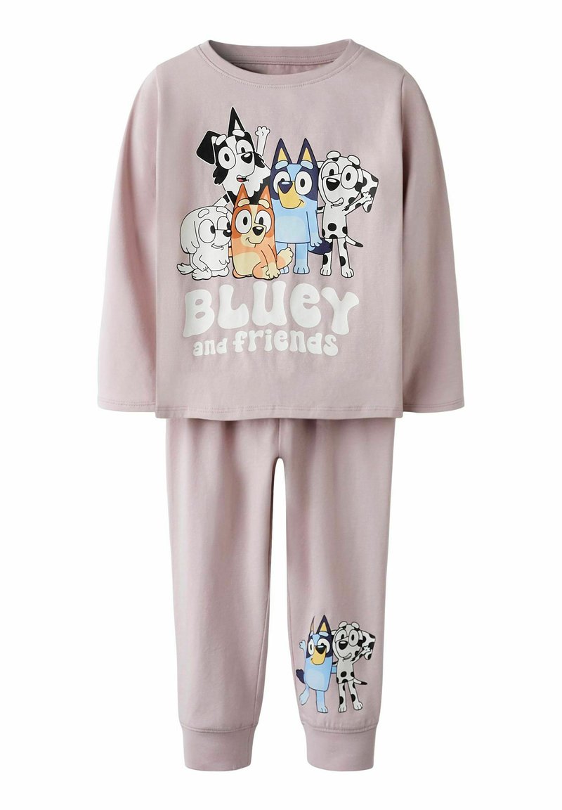Ljust lila barnpyjamas set med långa ärmar, prydd med tecknade hundkaraktärer och texten "Bluey och vänner" på överdelen samt två karaktärer på byxorna.