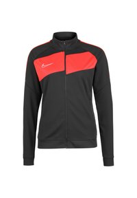 Schwarze Zip-Jacke mit rotem Akzent auf der Brust und den Schultern. Aus glattem Stoff gefertigt, mit langen Ärmeln und Stehkragen.