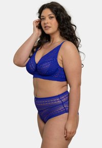 Ensemble de soutien-gorge en dentelle bleue et culotte taille haute avec des motifs géométriques, des bords festonnés et des bretelles ajustables, fabriqué dans un matériau doux et transparent.