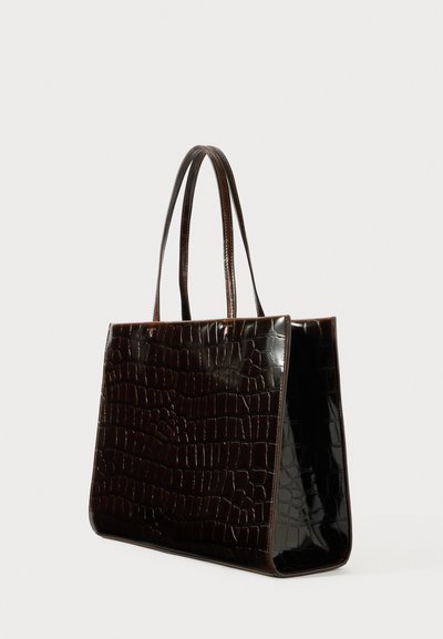 Ciemnobrązowa błyszcząca torba na ramię o teksturze krokodyla, prostokątna, z dwoma długimi uchwytami, wyeksponowana pod kątem na jednolitym tle.