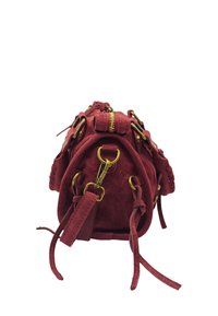 Sac à main en daim rouge avec des accessoires en métal doré, présentant une forme arrondie, des coutures décoratives et des sangles réglables. Fermeture zippée sur le dessus.