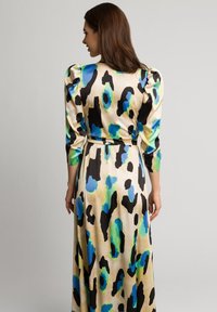 Długa sukienka z satyny z kolorowym, abstrakcyjnym wzorem w panterkę z akcentami w odcieniach teal, niebieskim i czarnym. Bufiaste rękawy oraz dopasowany detail w talii.