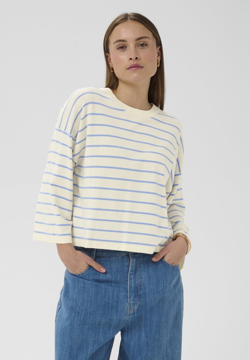 Sweat-shirt court jaune clair avec rayures horizontales bleues, col rond et coupe décontractée. Présente des épaules tombantes et des poignets côtelés.