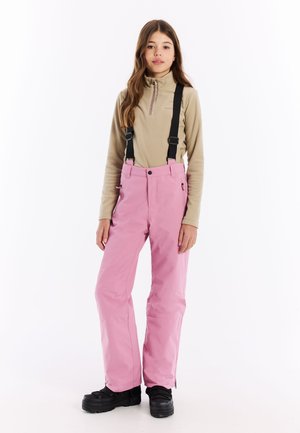 Rosa isolierte Schneehosen mit verstellbaren schwarzen Trägern, Reißverschlusstaschen und einer lockeren Passform, kombiniert mit einem beigefarbenen Fleece-Halbzip-Oberteil.