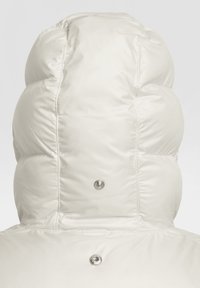 Abrigo acolchado blanco con una capucha estructurada y sobredimensionada. Acabado brillante y suave, con botones a presión plateados y textura acolchada en la parte posterior.