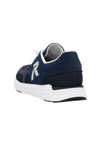 Baskets de sport bleu marine en maille et daim, avec une semelle en caoutchouc blanc et un détail de logo réfléchissant sur le côté.