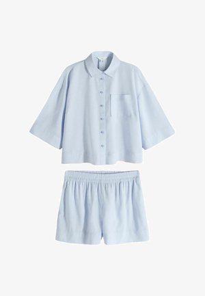 Camisa azul claro de manga corta con botones y bolsillo en el pecho, combinada con pantalones cortos de cintura elástica a juego.